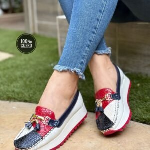Mocasín femenino en cuero con plataforma, acabado metálico y borlas. Moderno, cómodo y elegante para uso diario.